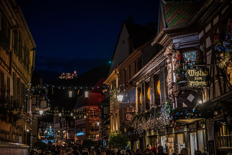 Marché de Noël alsacien illuminé de nuit avec ses chalets en bois traditionnels